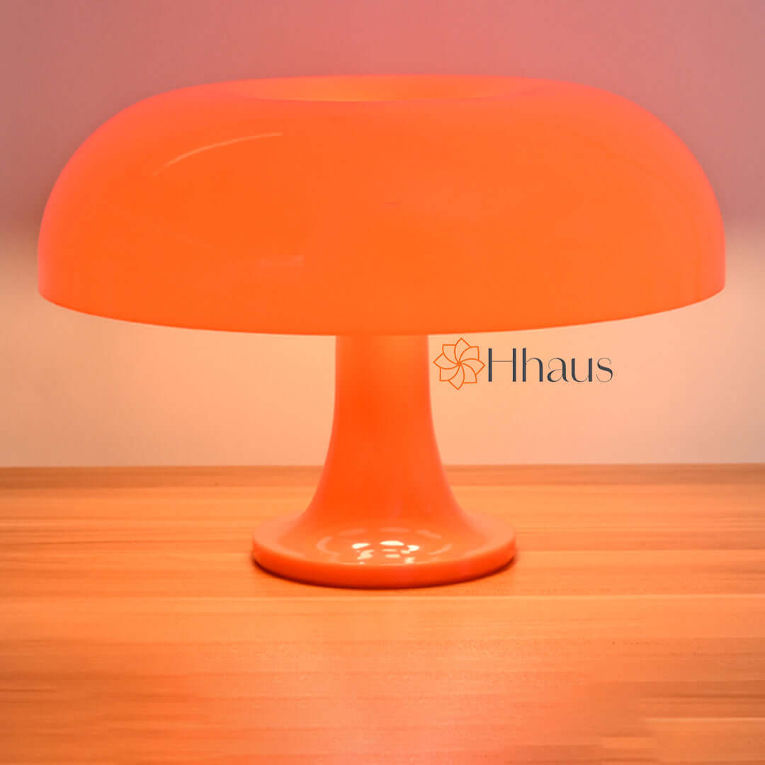 Orange coloured mushroom lamp shown powered on with white background
